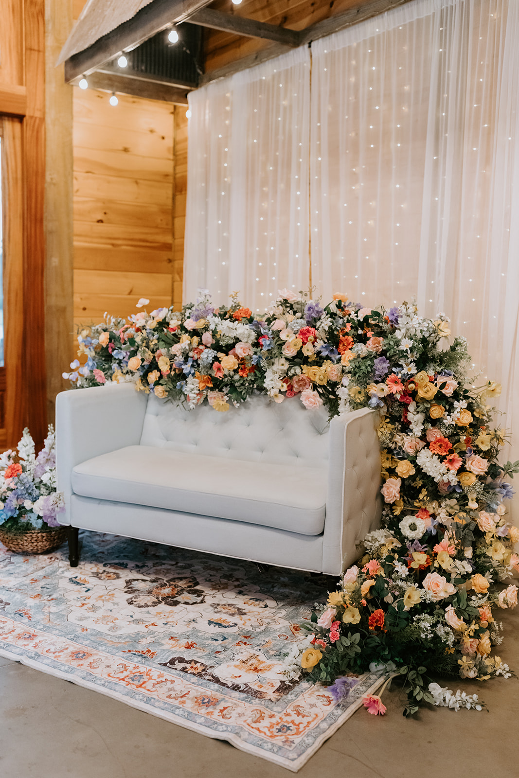 Leslie & Timothy sweetheart lounge with cascading florals and fairy-lit curtains at Covey Creek