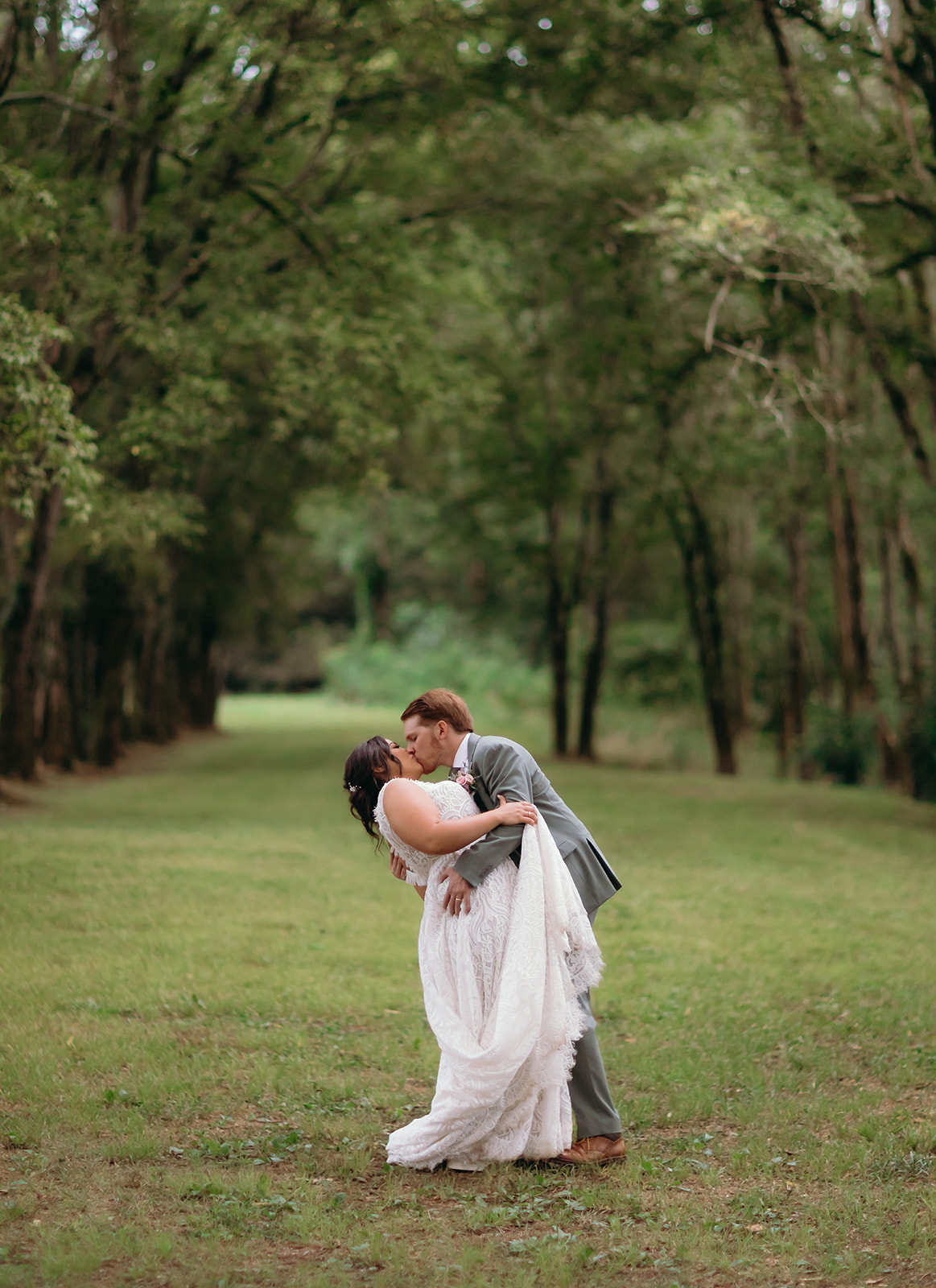 Meredith & Benjamin share a dip kiss along the Tunnel of Love tree-lined lane at Covey Creek