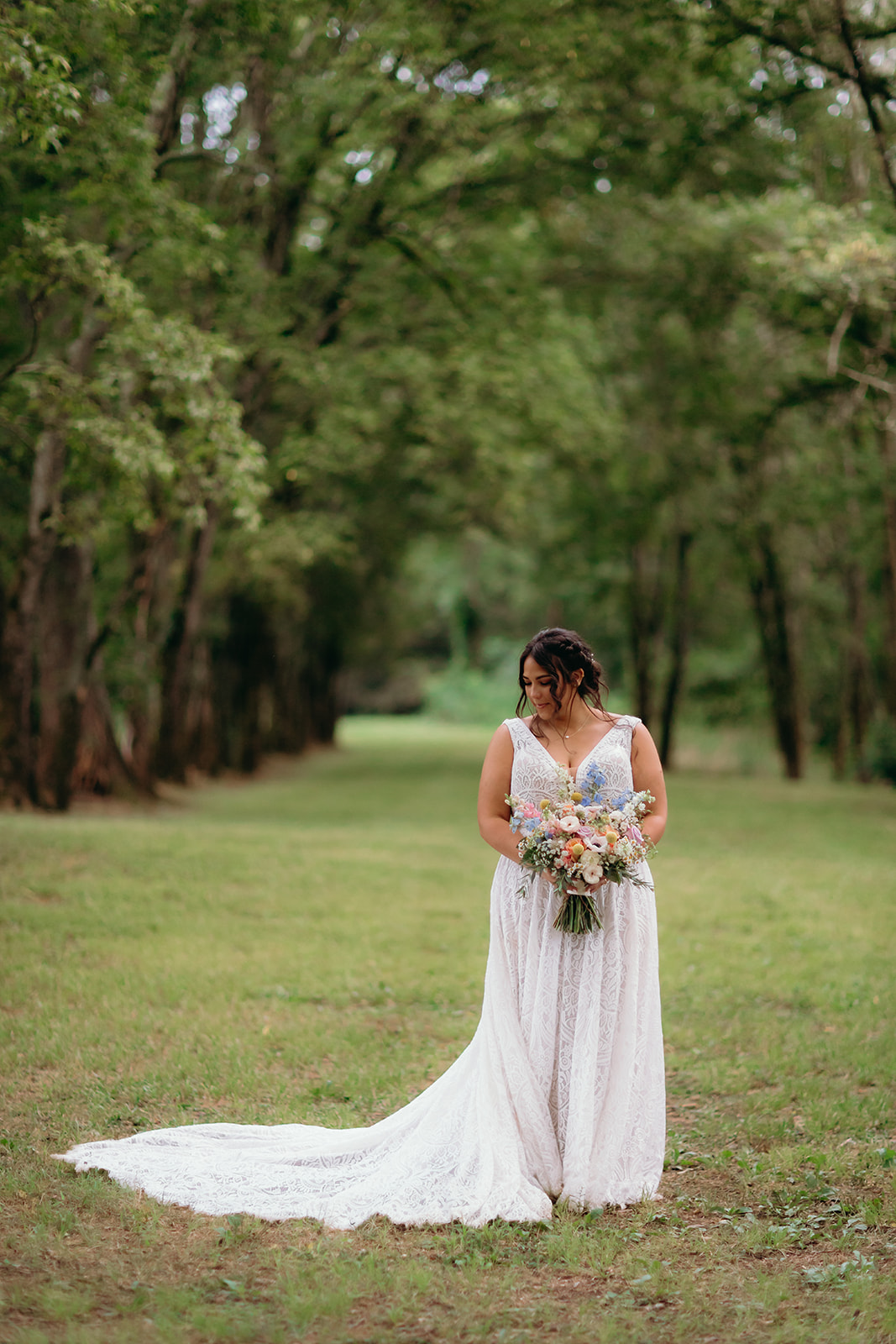 Meredith holds her wildflower bouquet on the Tunnel of Love path for Meredith & Benjamin at Covey Creek