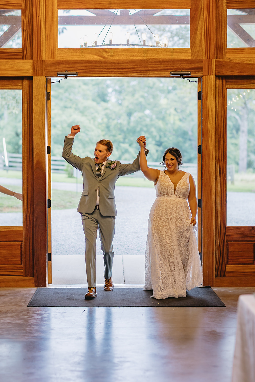 Meredith & Benjamin make a joyful grand entrance through the open barn doorway at Covey Creek