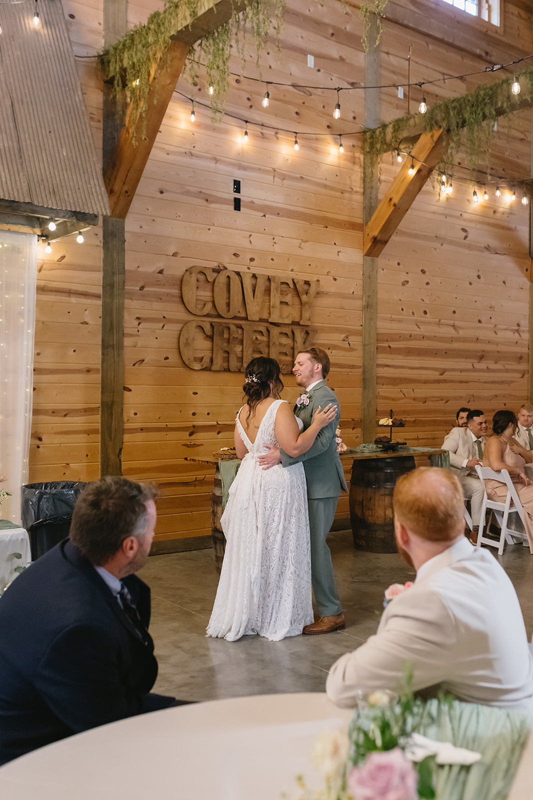 Meredith & Benjamin share their first dance under Edison lights in the barn at Covey Creek