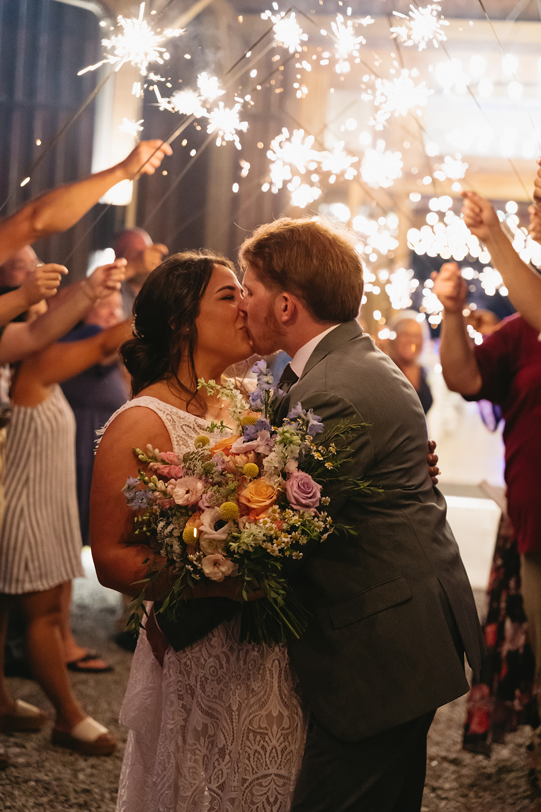 Meredith & Benjamin kiss under guest sparklers during their night exit send-off at Covey Creek