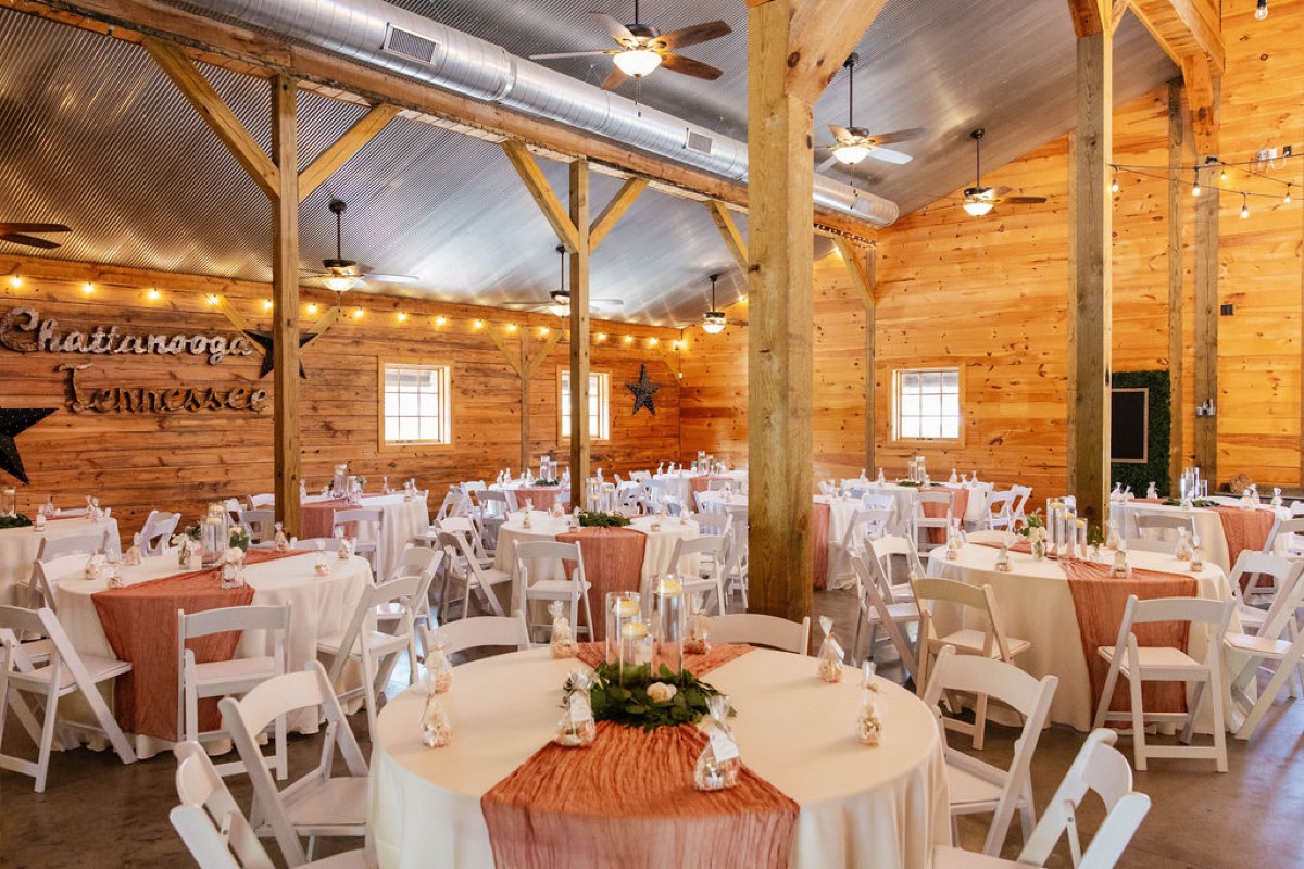 Raven & Jackson reception hall at Covey Creek with white tables, terracotta runners, floating candles, and string lights