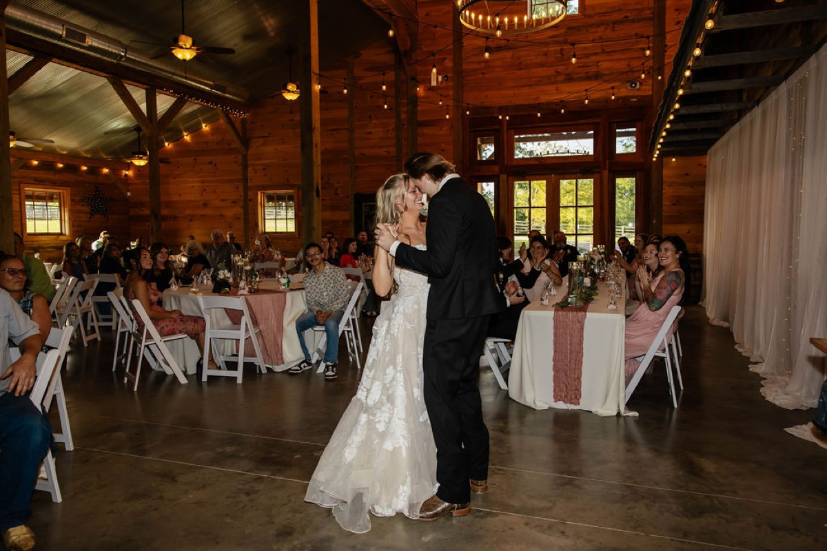 Raven & Jackson share their first dance under string lights in the Covey Creek reception barn