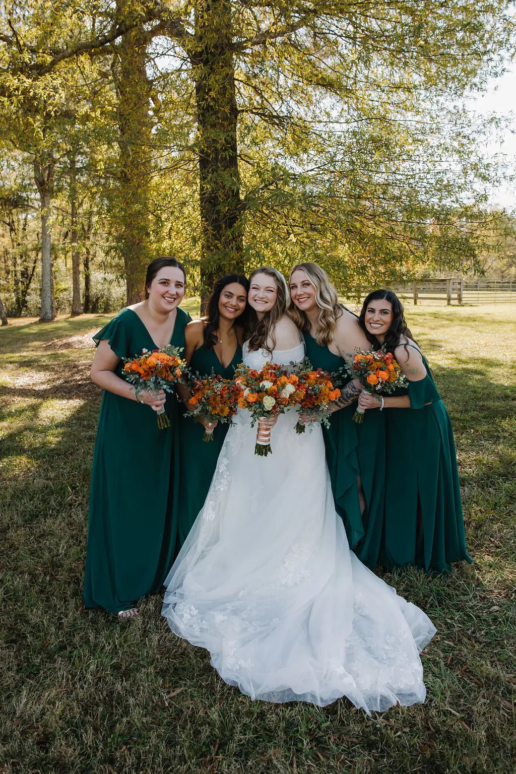 Rebecca & Troy’s bridal party: bride with four bridesmaids in forest-green gowns and autumn bouquets at Covey Creek.