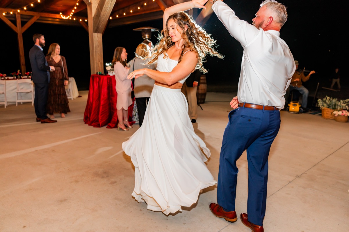 Sarah & Adam twirl under pavilion string lights during their Covey Creek wedding reception