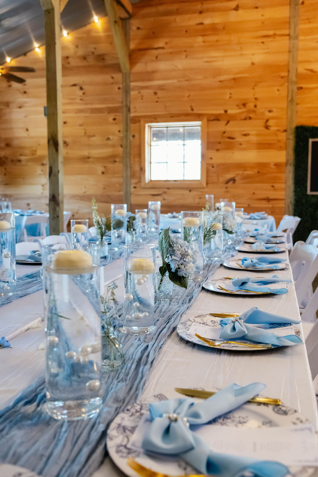 Shelbie & Callaway long reception table at Covey Creek with blue runner, pearl candles, and floral place settings