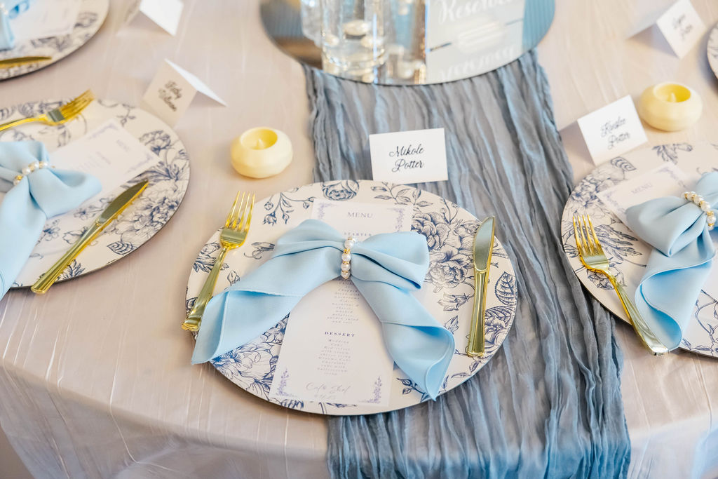 Shelbie & Callaway place settings with blue floral plates, pearl-bow napkins, and menus at Covey Creek