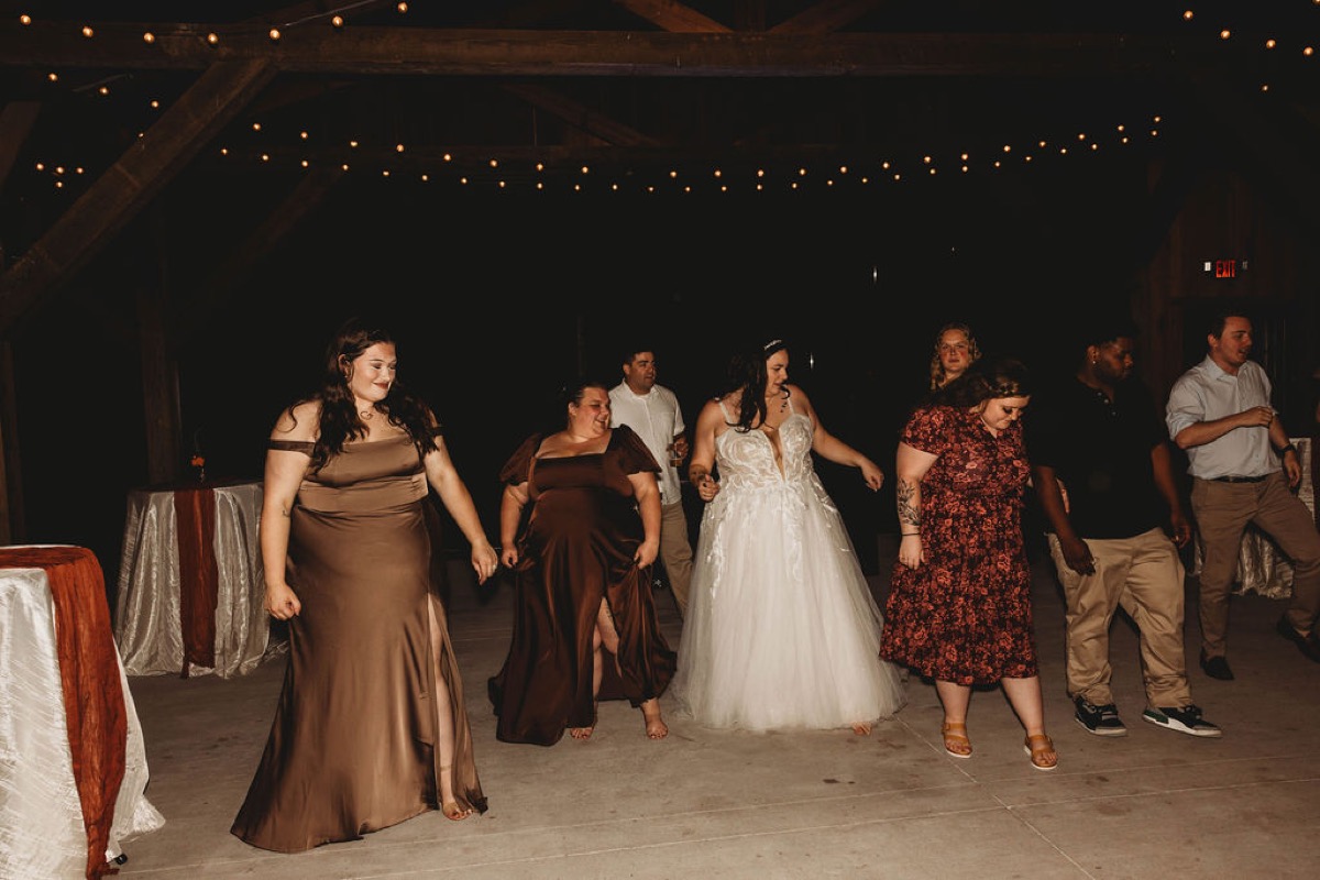 Tori leads a line dance with guests under string lights on the Patio at Covey Creek reception