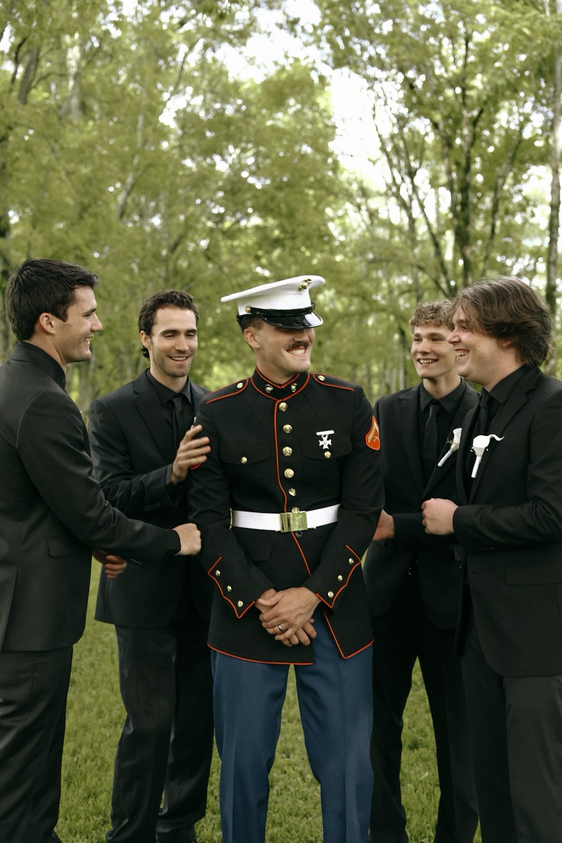 Brody in Marine dress blues laughs with four groomsmen in black at Cadence & Brody's Covey Creek wedding