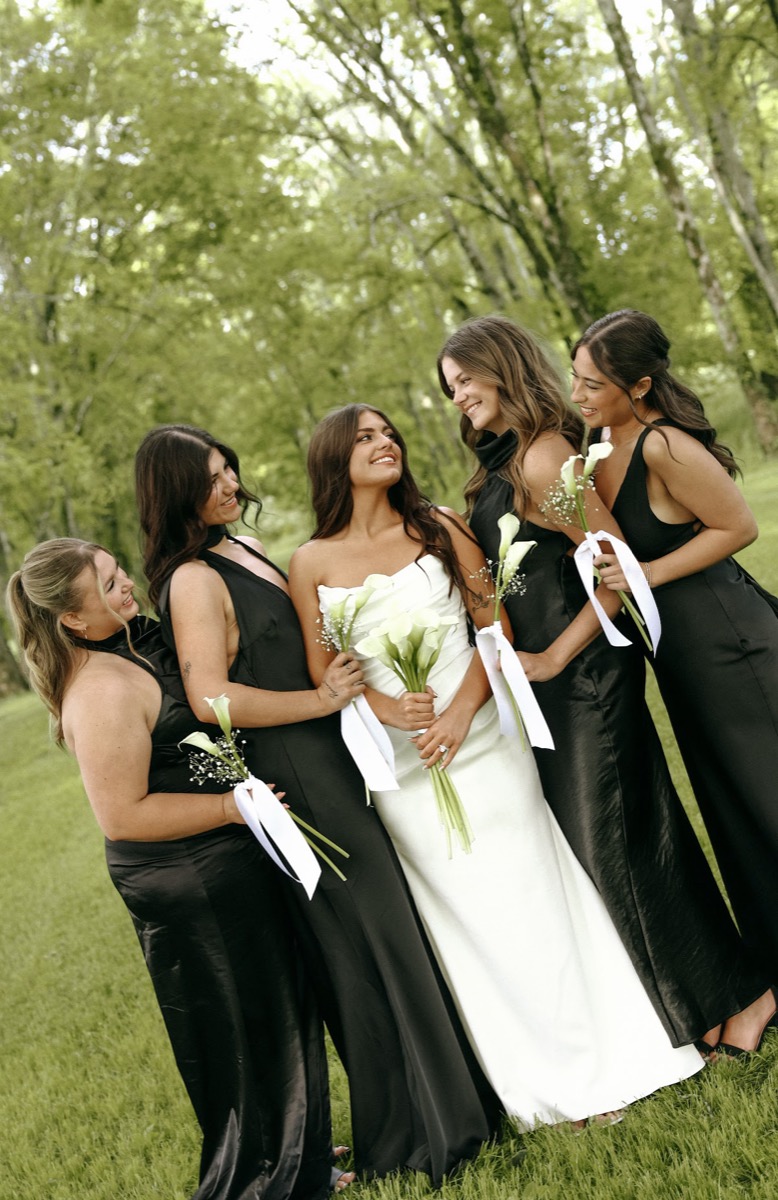 Cadence smiles with four bridesmaids in black and calla lilies at Cadence & Brody's Covey Creek wedding