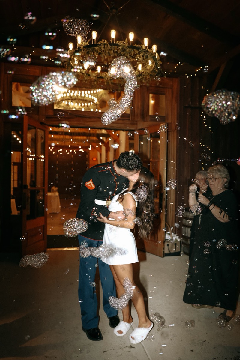 Cadence & Brody kiss in a swirl of bubbles under the barn chandelier during their Covey Creek send-off