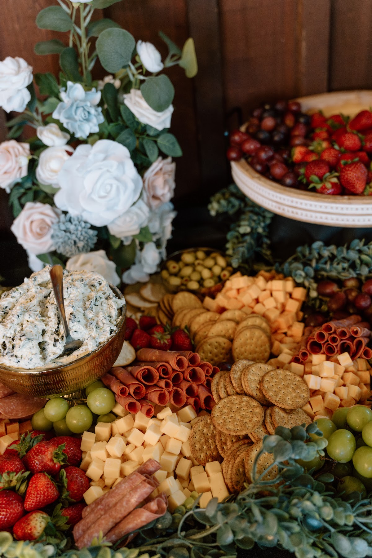 Charcuterie with strawberries, cheese, and florals fills a grazing table for Katelynn & Justin at Covey Creek