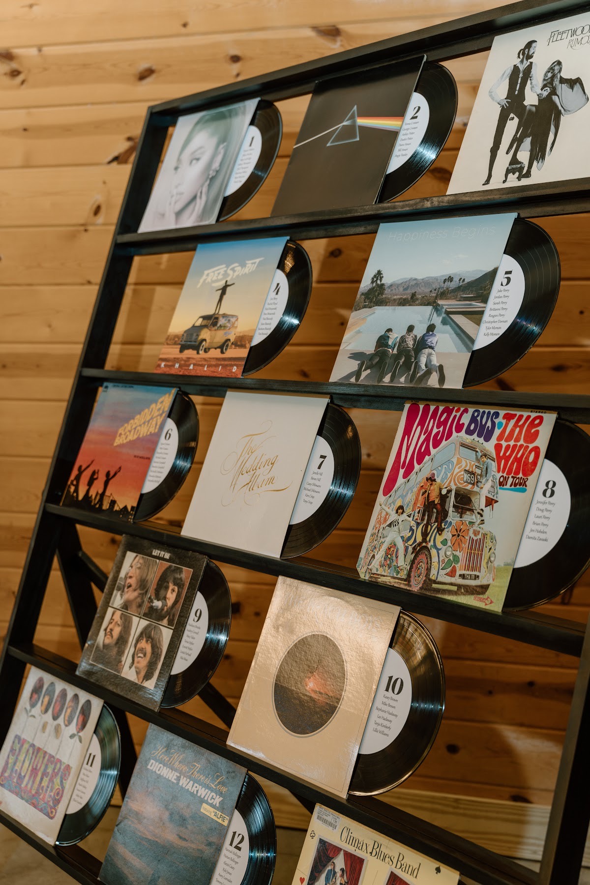 Vinyl album covers form a music-themed seating chart for Katelynn & Justin against wood walls at Covey Creek