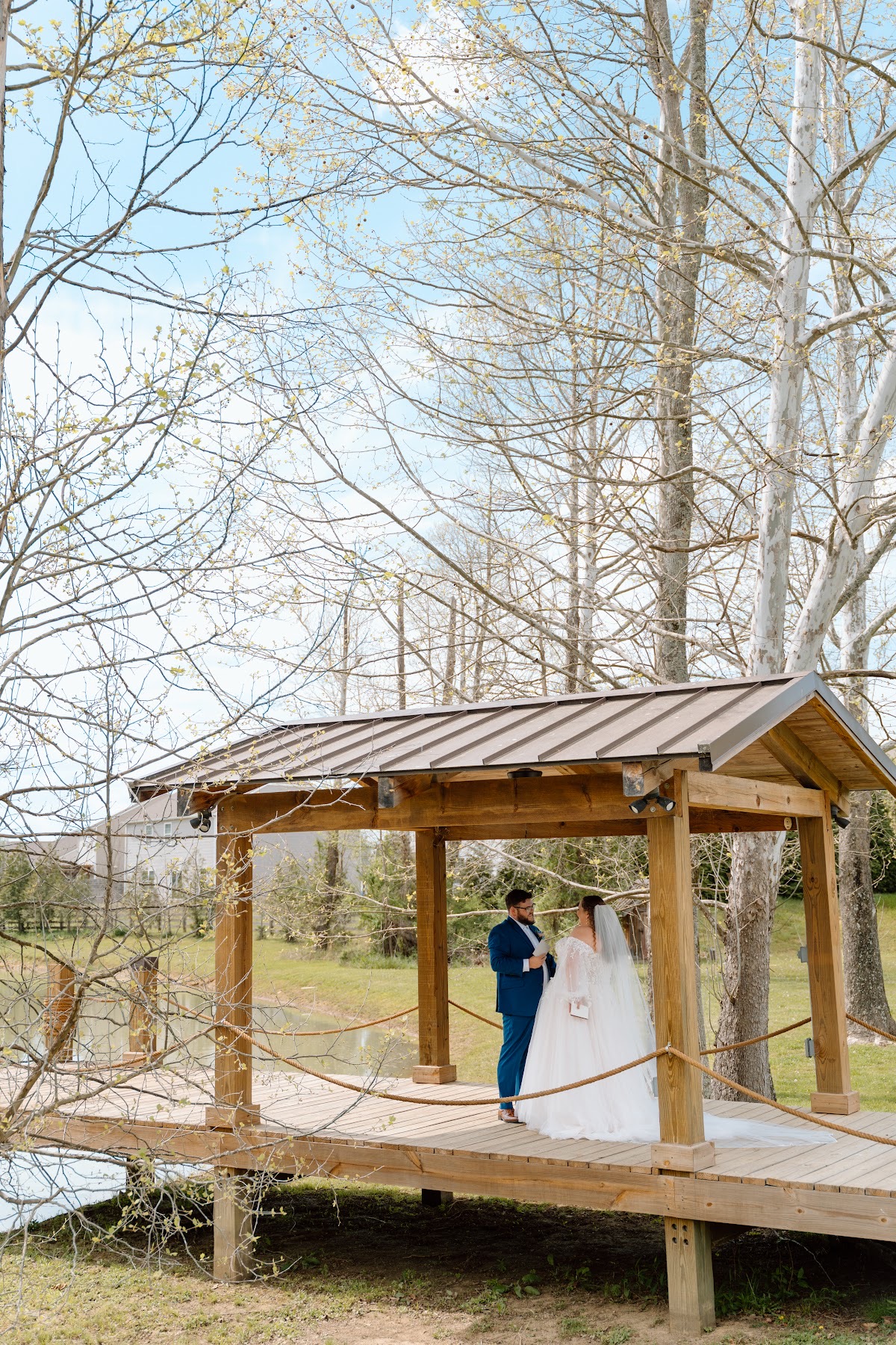 Katelynn & Justin share a quiet moment on the Pond dock pavilion among spring trees at Covey Creek