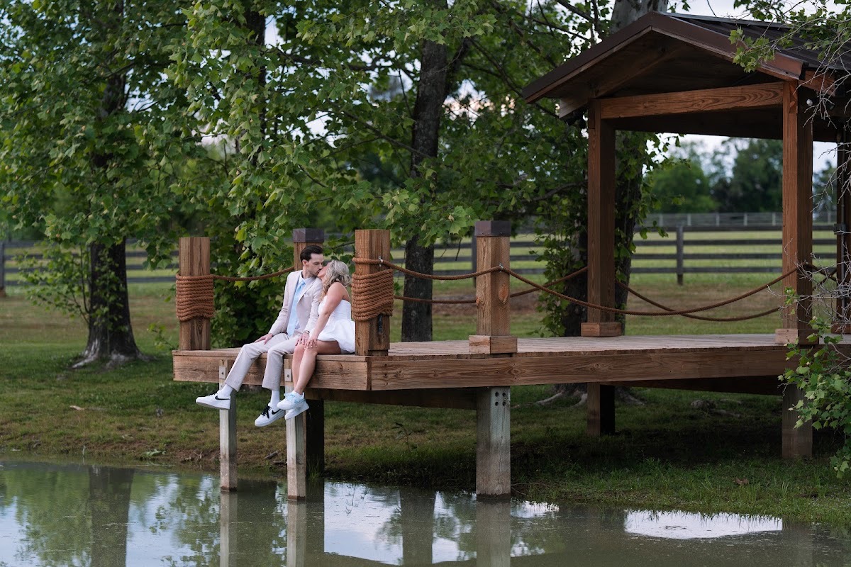 Kyley & Nick share a kiss on the wooden Pond dock in sneakers after their wedding at Covey Creek