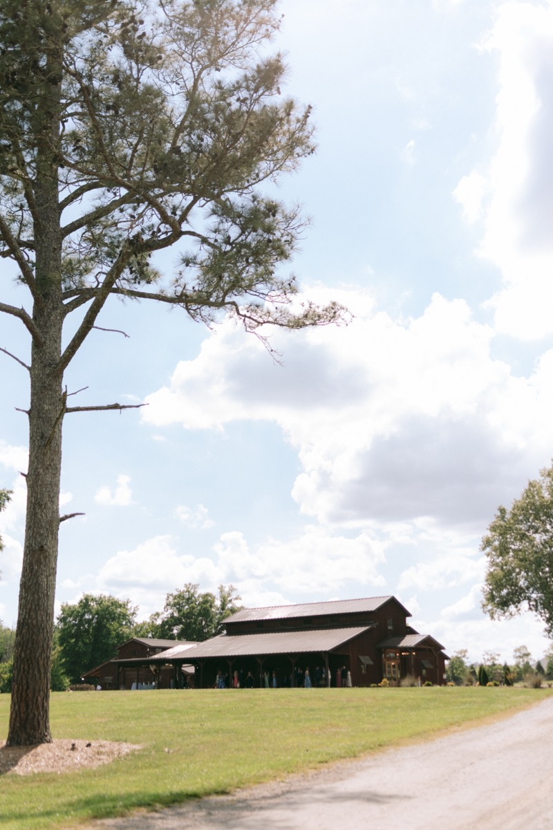 Rachel & Ben wedding guests gather on the porch of the rustic reception barn at Covey Creek.