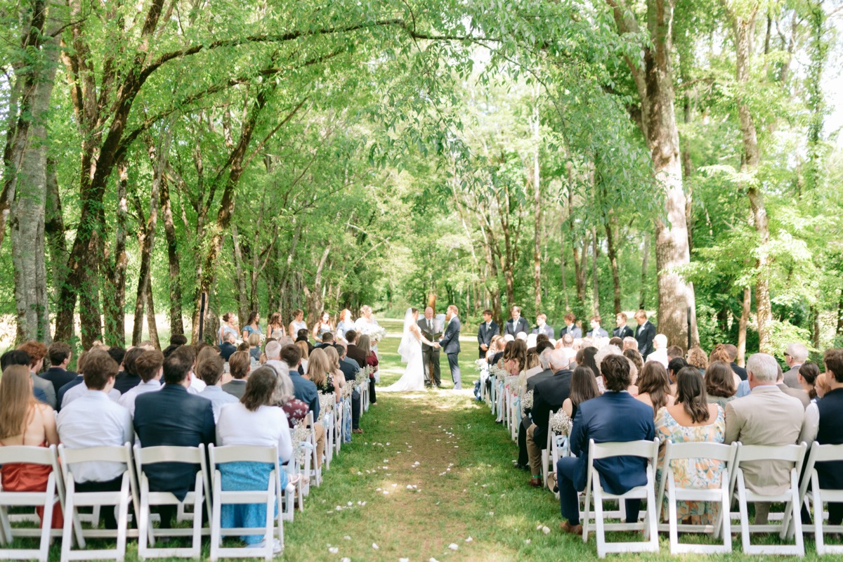 Rachel & Ben exchange vows under the Tunnel of Love tree canopy on a sunny spring day at Covey Creek.