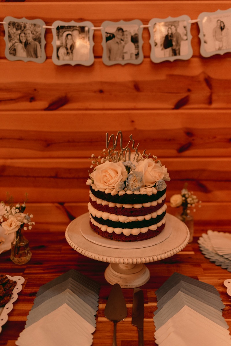 Rachel & Ben floral naked wedding cake with Mr & Mrs topper at the indoor reception, Covey Creek.