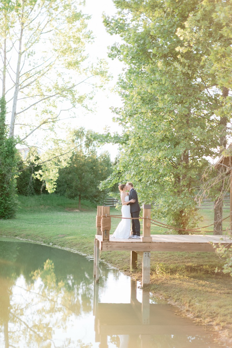 Rachel & Ben kiss on the wooden Pond dock in warm golden-hour spring light at Covey Creek.
