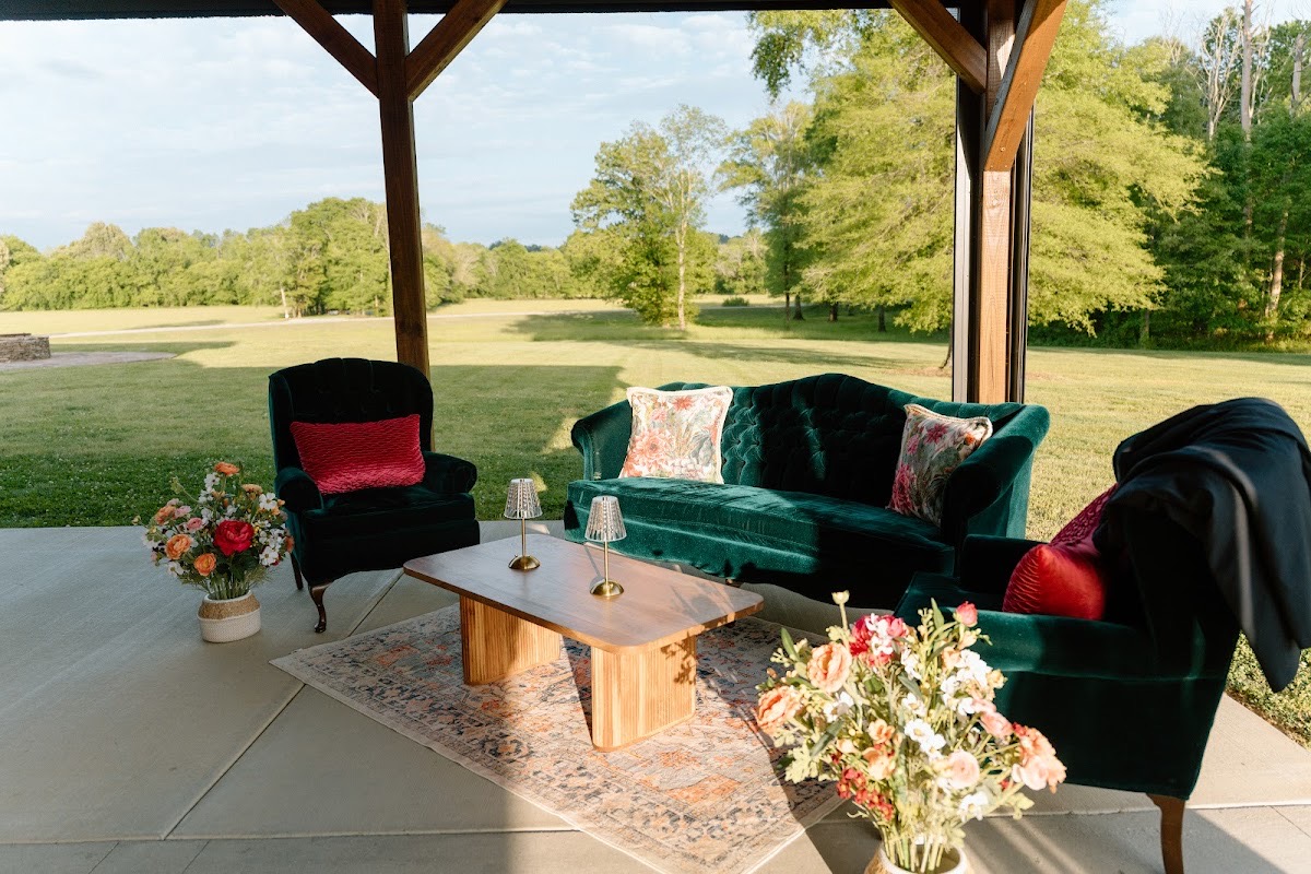 Emerald velvet lounge seating with peach florals under the pavilion for Stephanie & Josh at Covey Creek