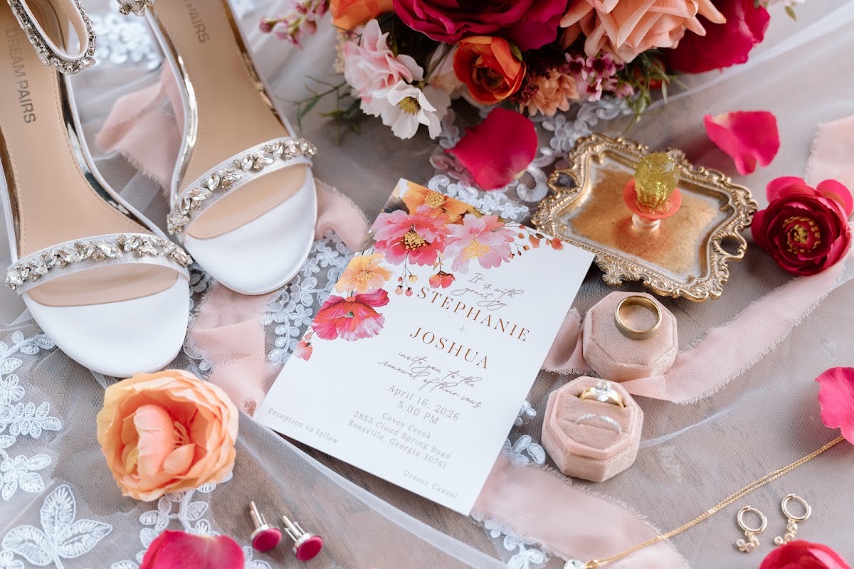 Stephanie & Josh vow-renewal invitation flat lay with heels, rings, and pink florals at Covey Creek